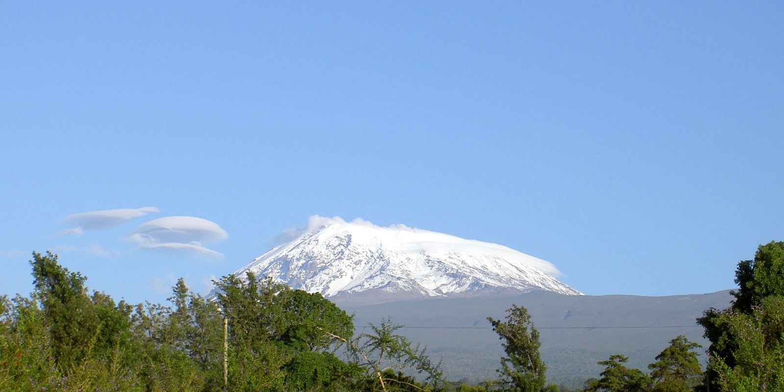The snow-capped summit of Kibo on Mount Kilimanjaro above the clouds
