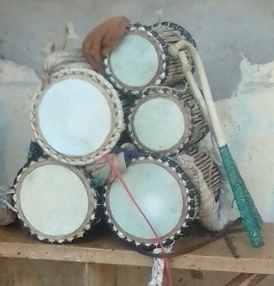 A stack of hourglass talking drums with cords and curved beaters in Offa, Kwara State, Nigeria