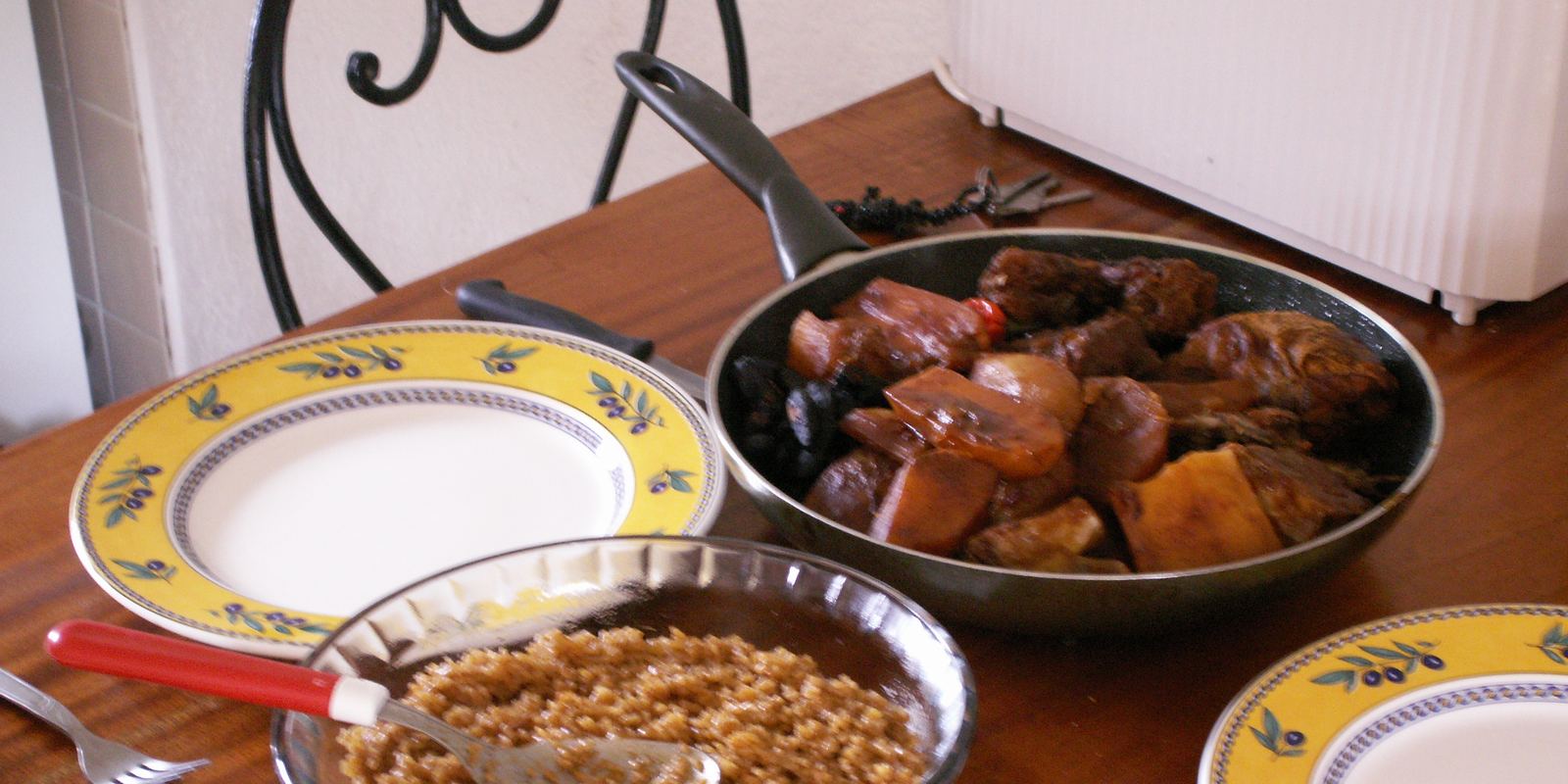 A large shared platter of thieboudienne with fish, vegetables and red rice
