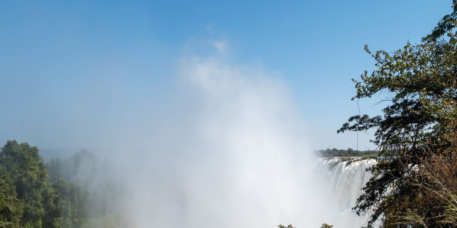 Water thundering over Victoria Falls with mist rising